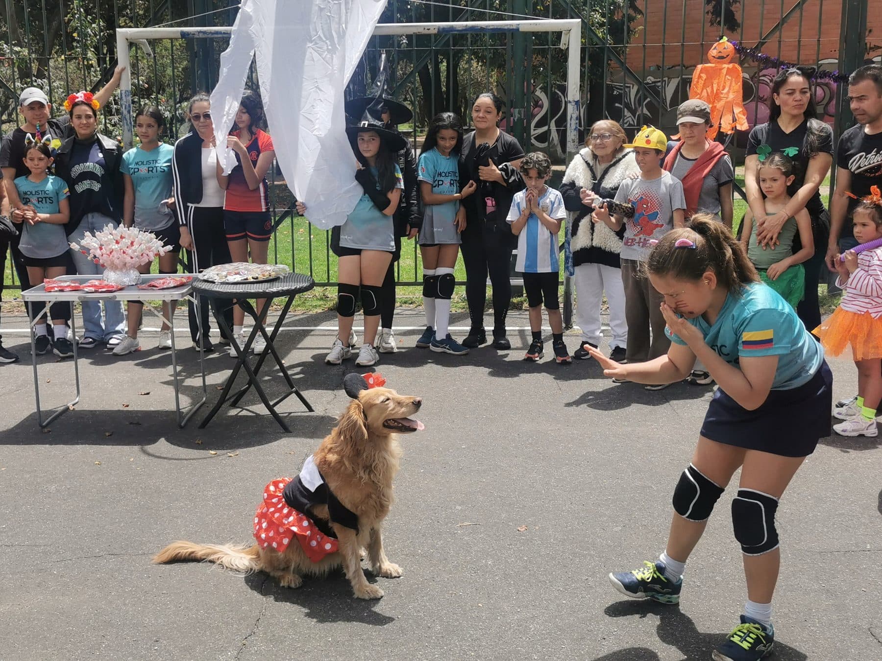 Actividad recreativa de HSC con niños disfrazados y una perrita en la cancha